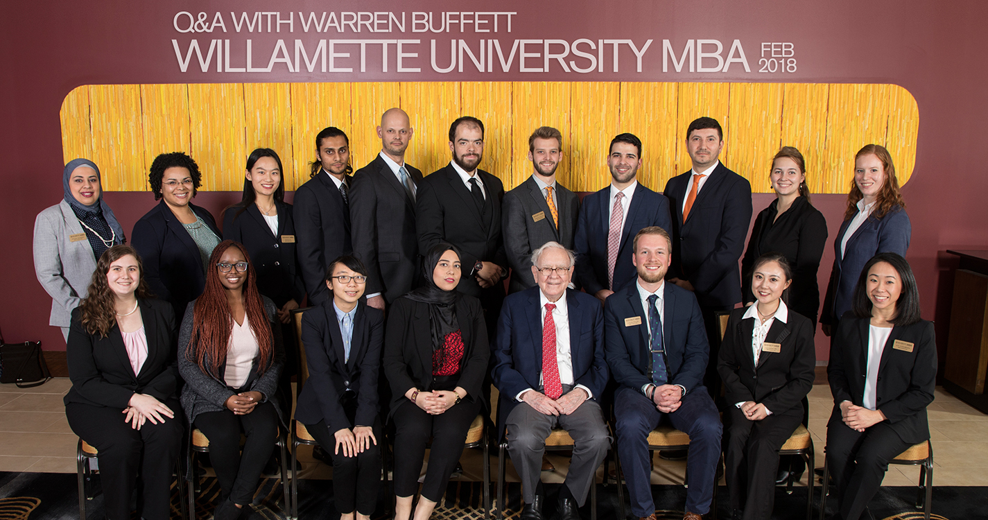 Students from Atkinson Graduate School of Management pose for a photo with Warren Buffett.