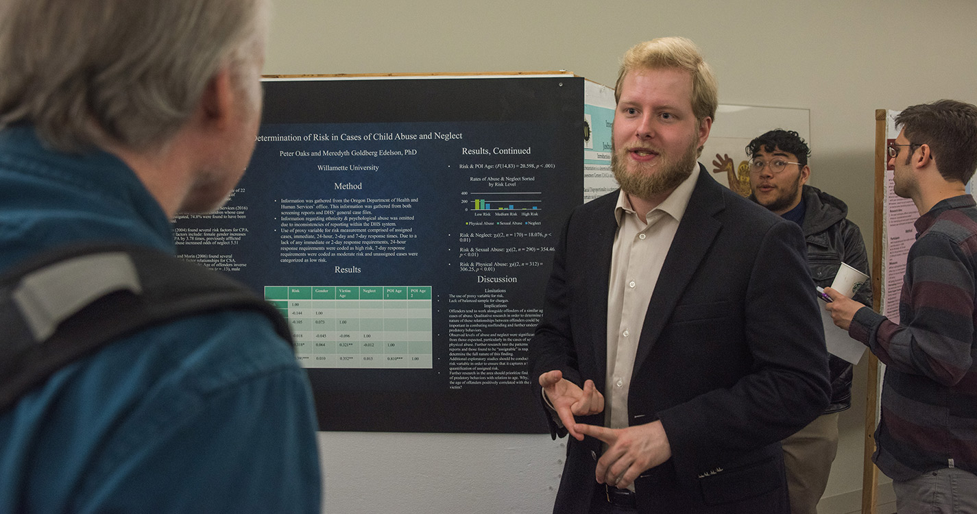 Student speaks before a poster of research