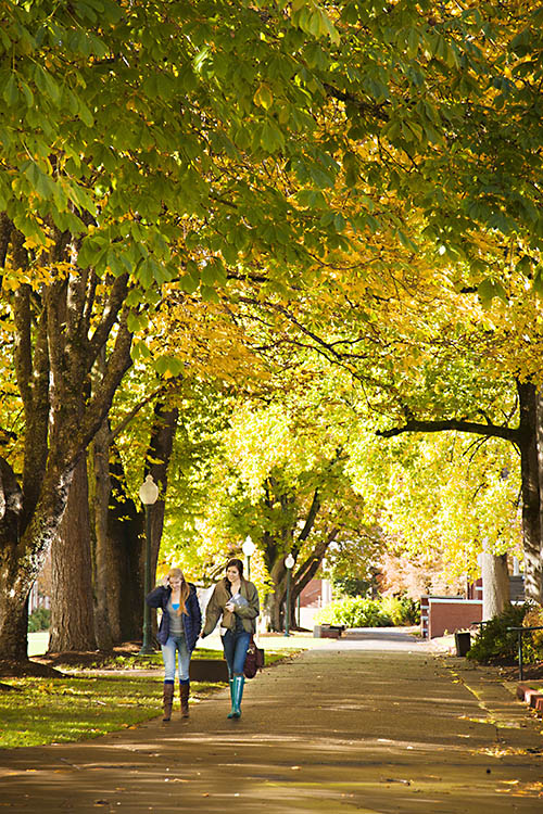 Two students walk through Salem Campus in early autumn.