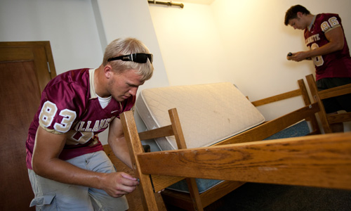 Student-athletes are a great help to first-year students by assembling furniture.