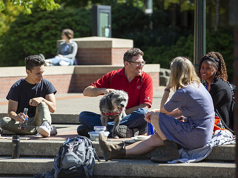 Willamette students, professor and a dog visiting outside