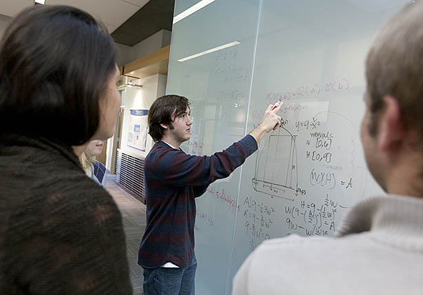 students studying at a whiteboard in Ford Hall Hearth