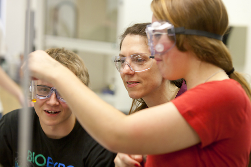 Holman works with students in a chemistry lab class.
