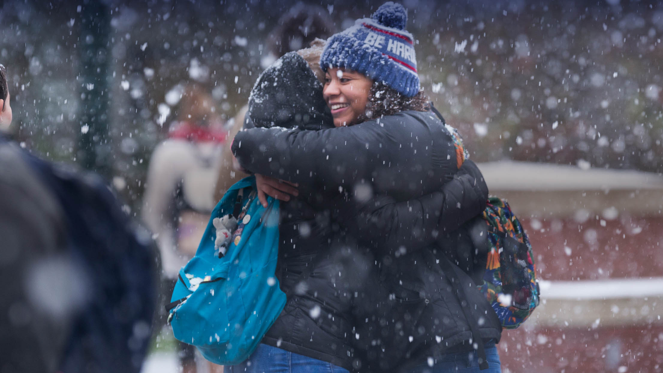 Willamette students hugging on a snowy day