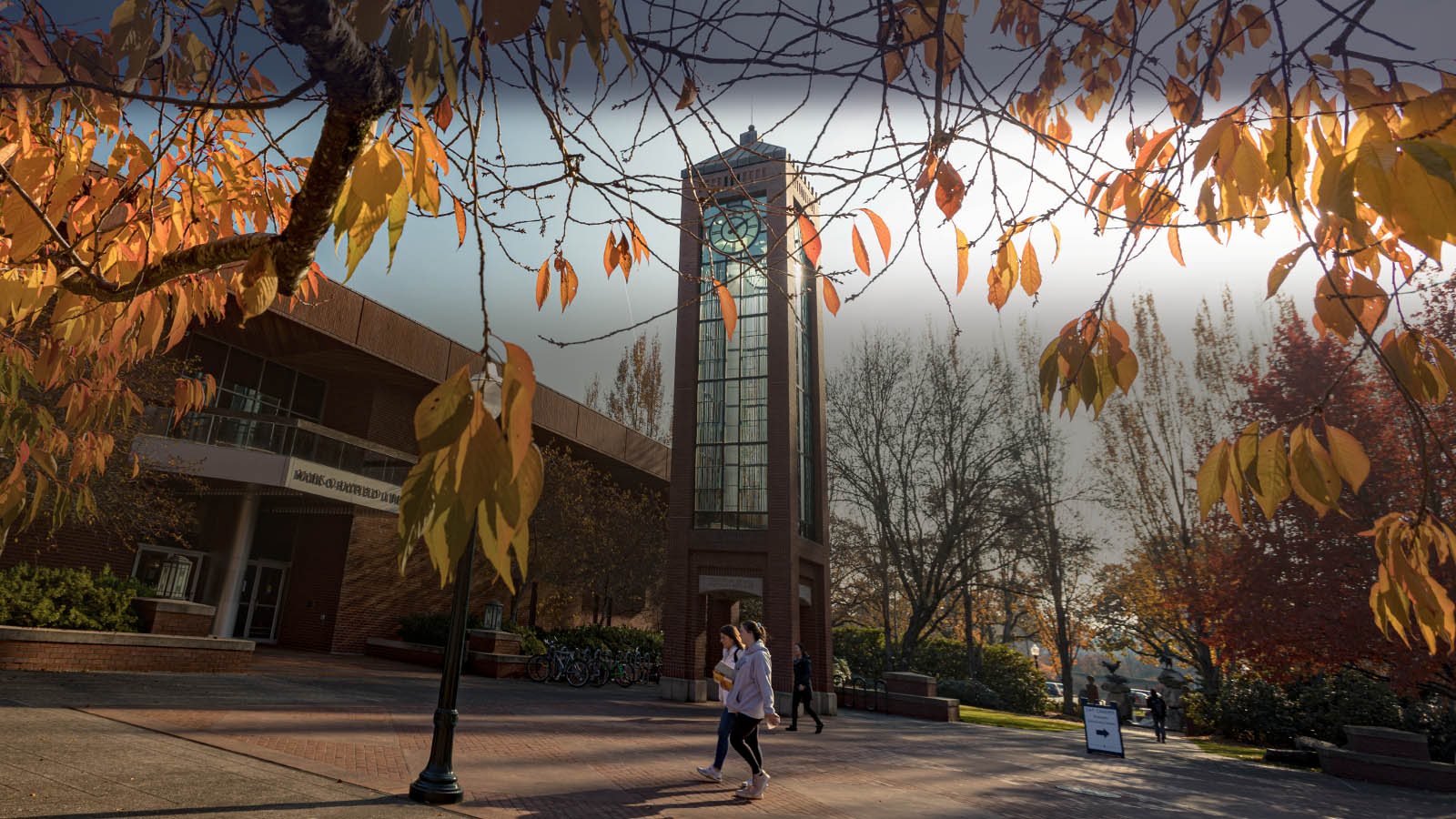 Willamette students walk past the Hatfield Library on an autumn day at Salem campus.