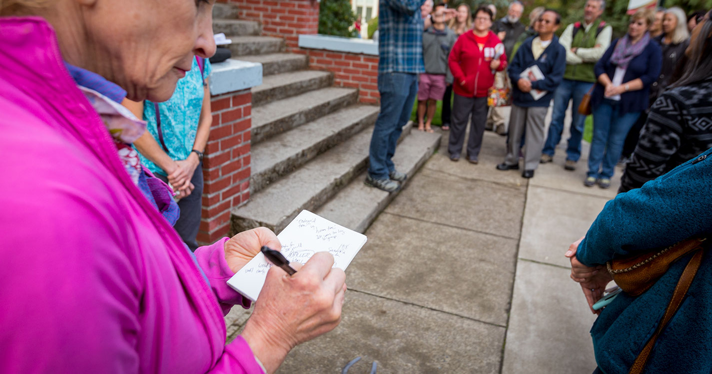 Willamette parent taking notes at outdoor presentation