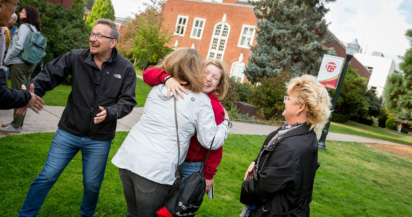 Parents greet a student with a hug