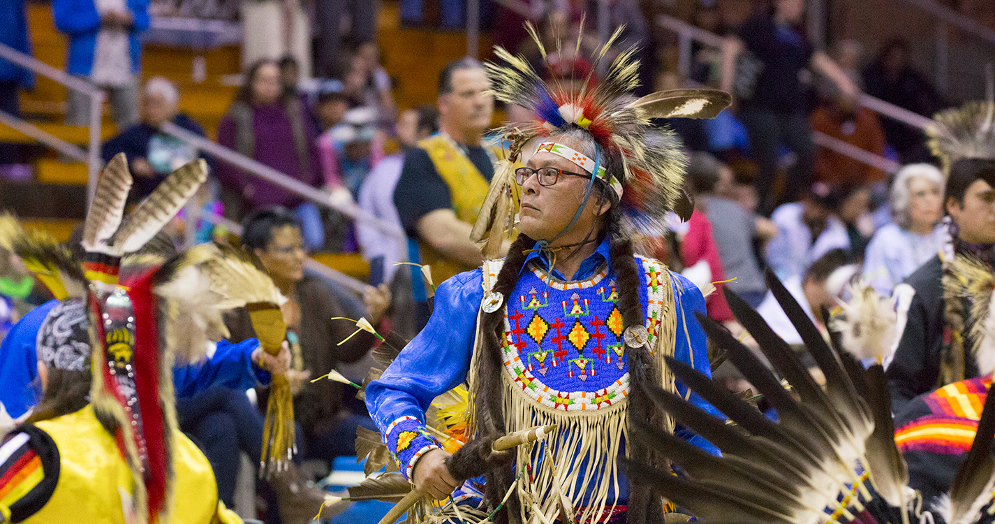 A man dressed in traditional regalia dances in the Social Pow wow. 