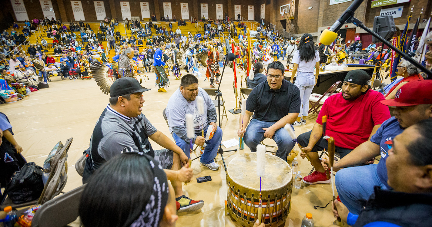 A drum group sitting in a circle plays at the annual Social Pow wow. 