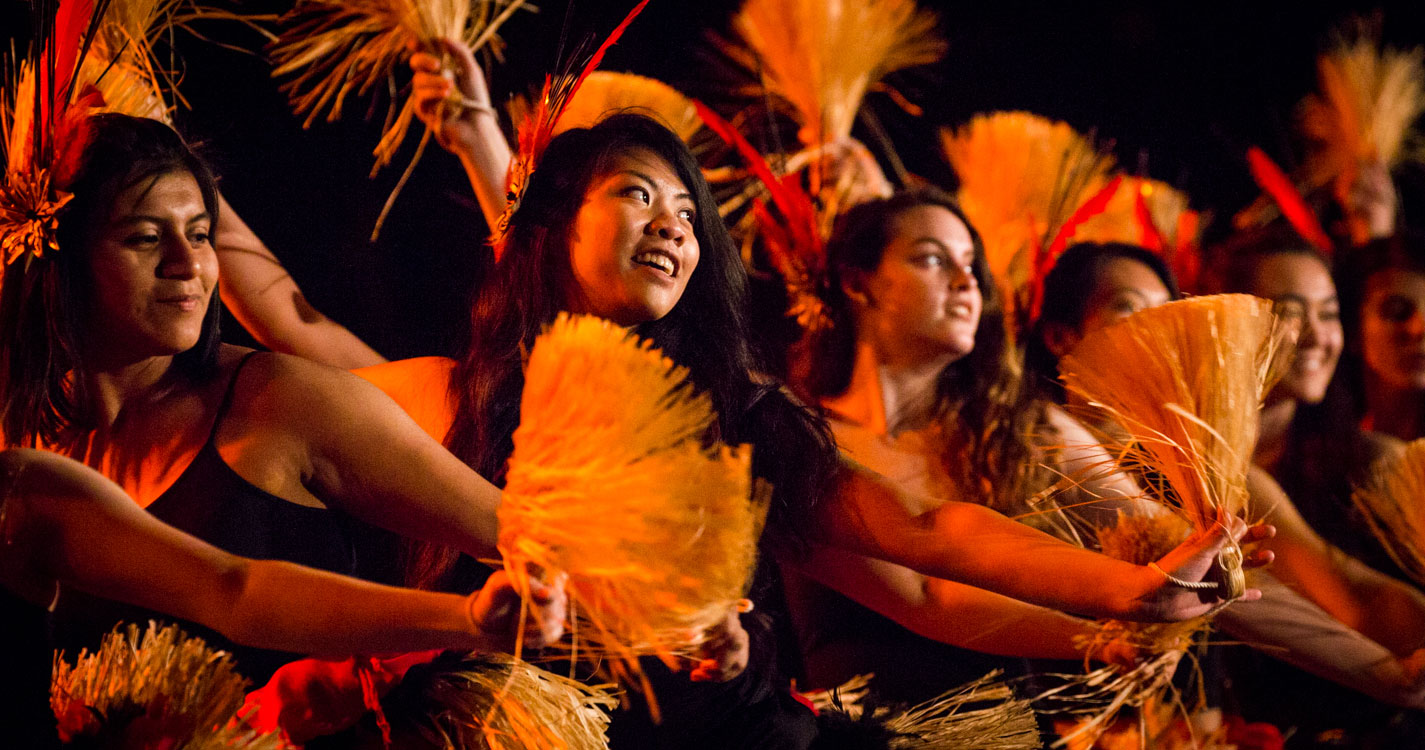 Willamette students dance with fans in the luau