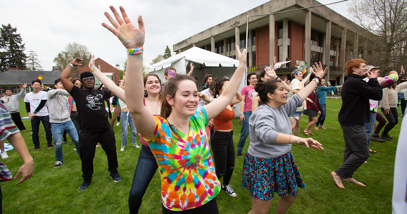 Students raise their arms to the sky while doing "jazzercise" on Brown Field at Wulapalooza.