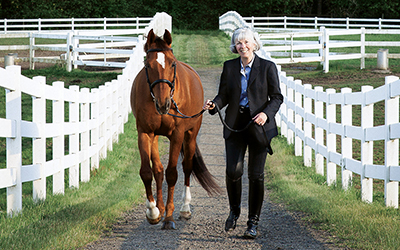 Debra Ringold, dean of Atkinson Graduate School of Management, walks with her horse Larry