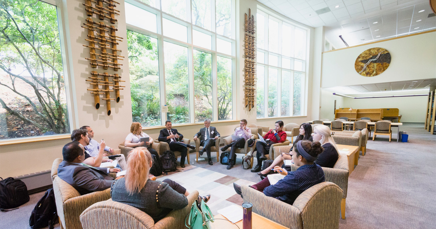 Dean Bridgeman and new 1L students sit in chairs arranged in a circle