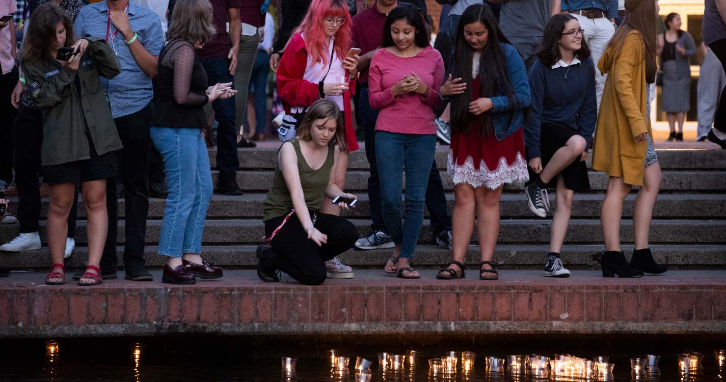 A new student releases her candle to the Mill Stream during Matriculation.