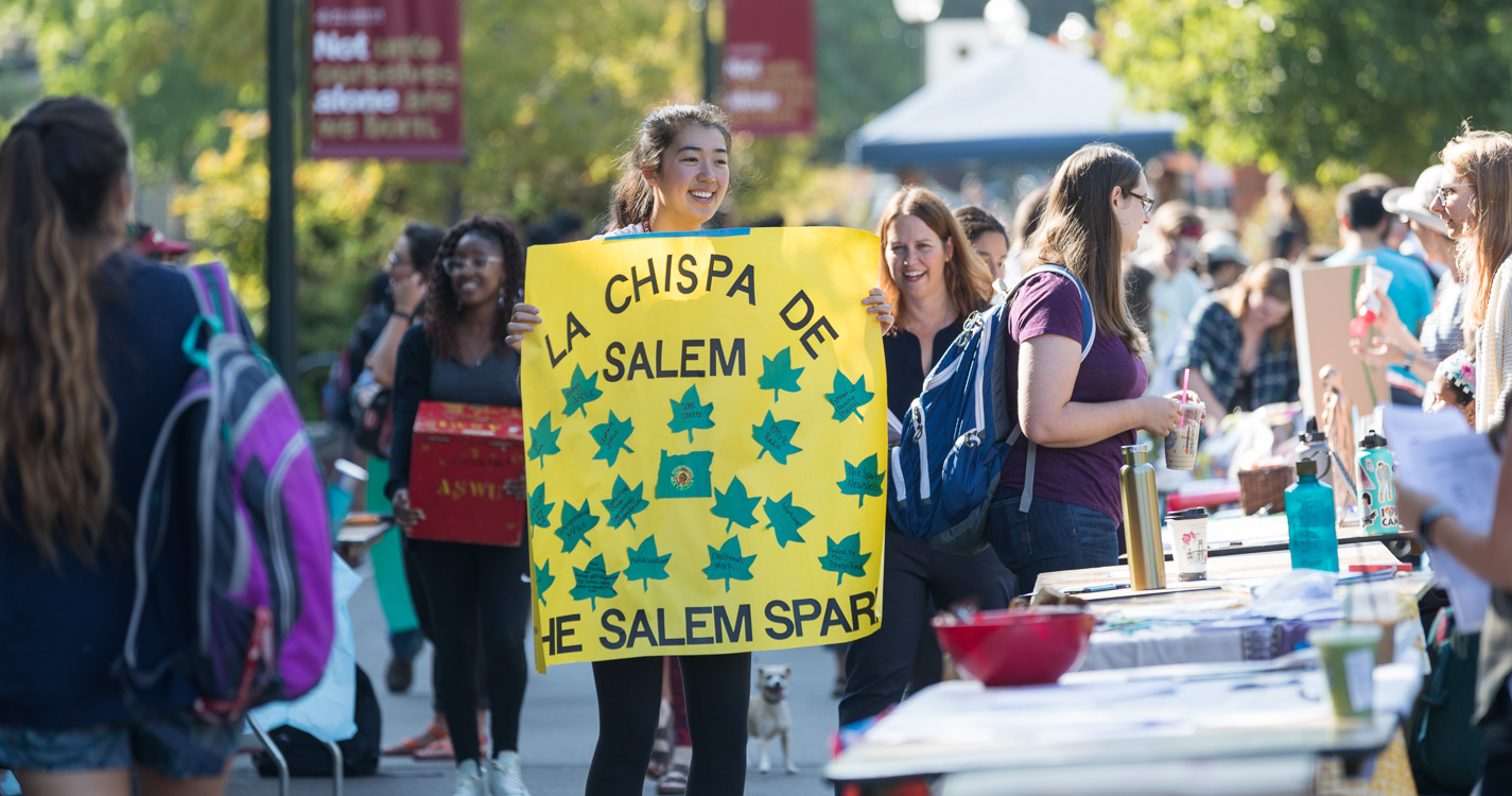 Student holding sign that says La Chipsa de Salem the Salem Spark