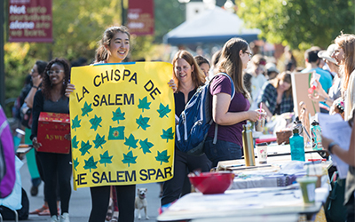 Student holding sign that says La Chipsa de Salem the Salem Spark