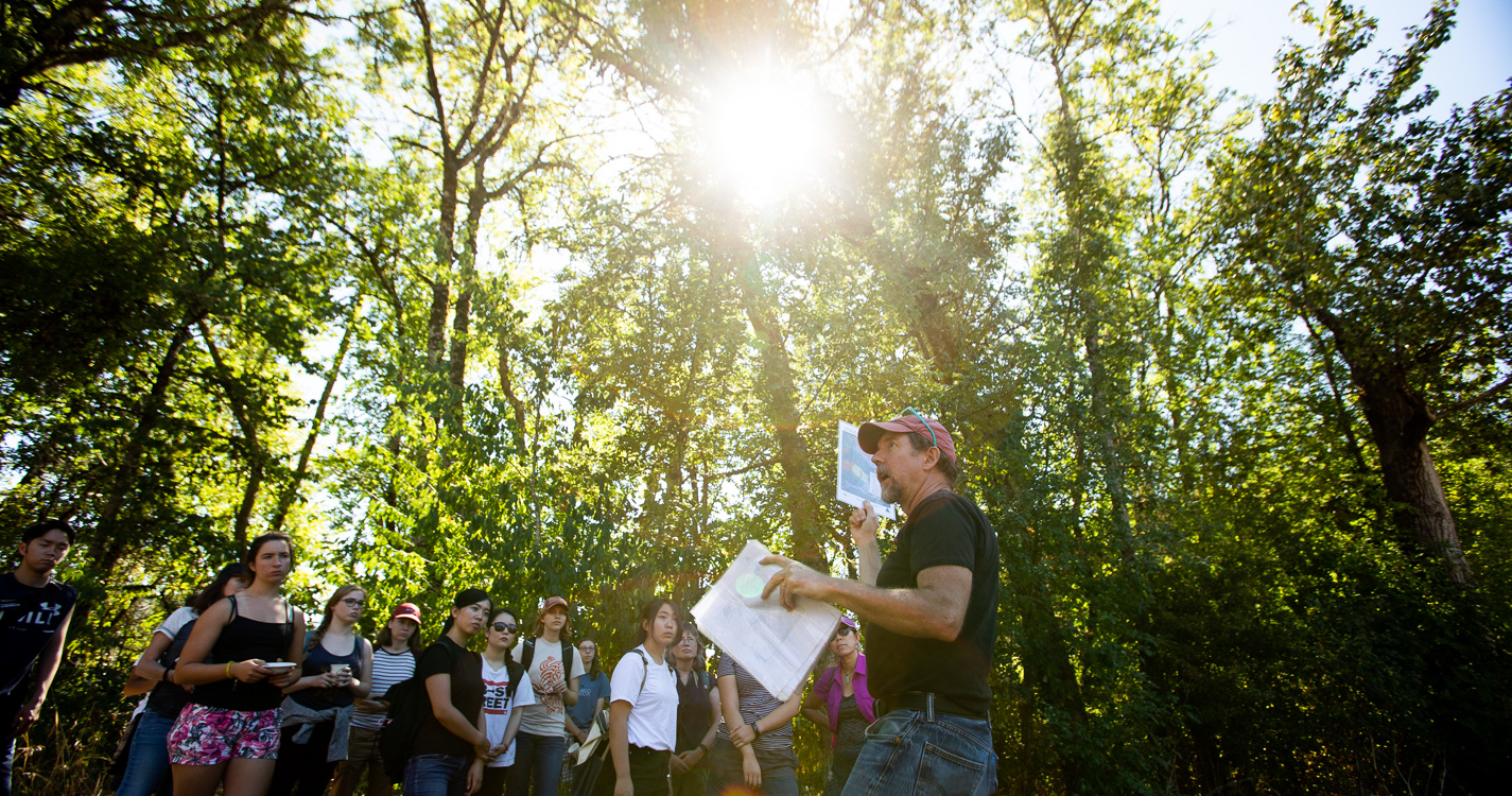Professor Joe Bowersox leads a group through the woods at Willamette's Zena campus