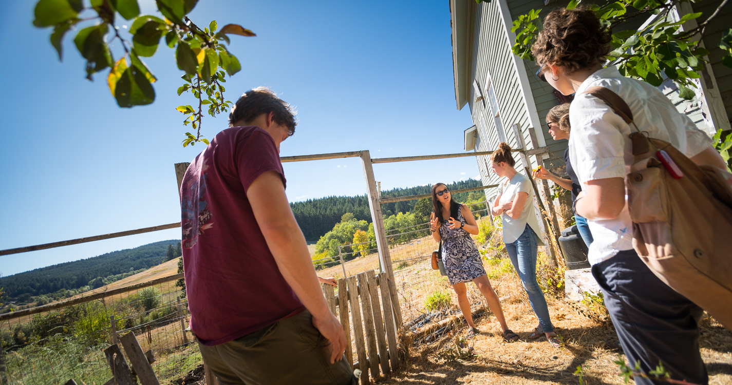 students and alumni visit near a building on Willamette's Zena campus