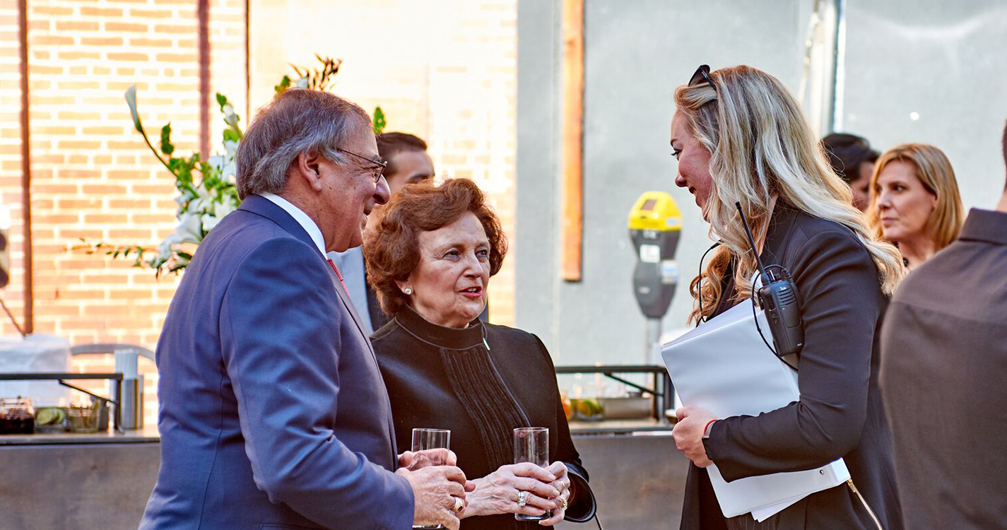 Kate Steffy speaks with former White House Chief of Staff Leon Panetta and Sylvia Panetta, his wife, at a work event.