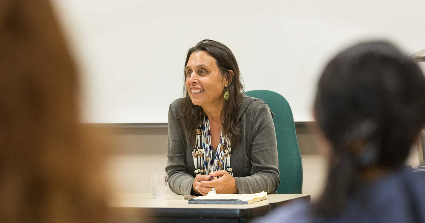 Winona LaDuke sits before a classroom of students and speaks