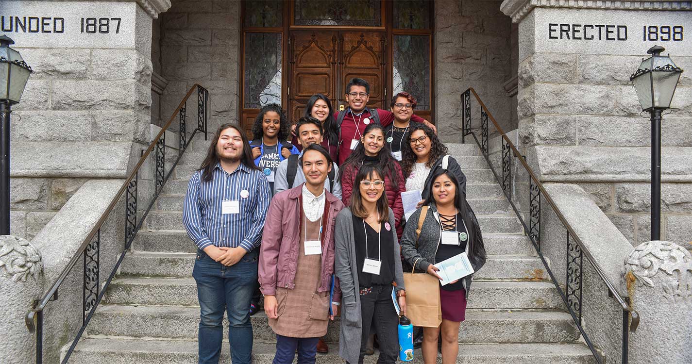 Eleven Willamette students stand on the steps of a building at the Pacific Northwest Students of Color Conference