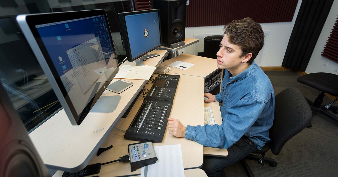 Student works on sound production in front of a computer. 