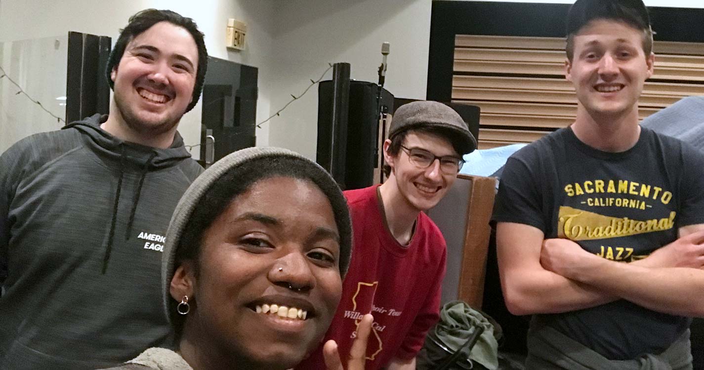 Students smile for photo at recording studio. 