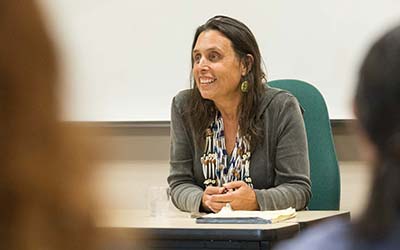 Native American woman speaks to students