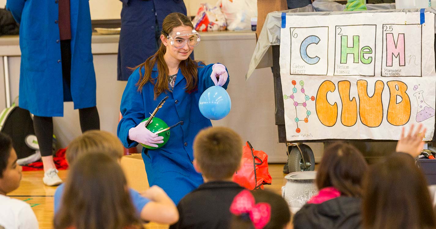 Kelli O'Brien ’22 performs a chemistry experiment at an elementary school.