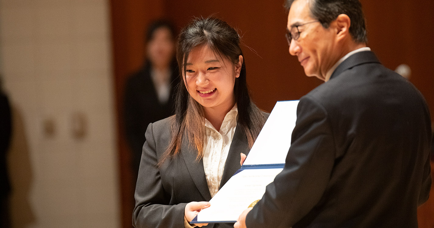 President Hiroshi Takahashi hands a student a certificate