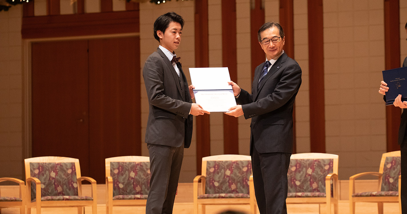 President Hiroshi Takahashi hands a student a certificate