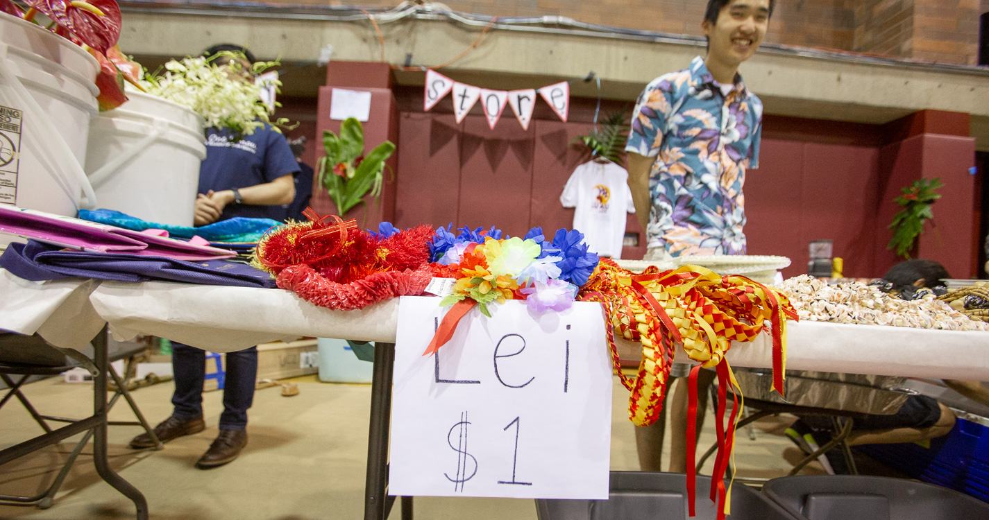 a table covered with leis and sign: "Lei $1"