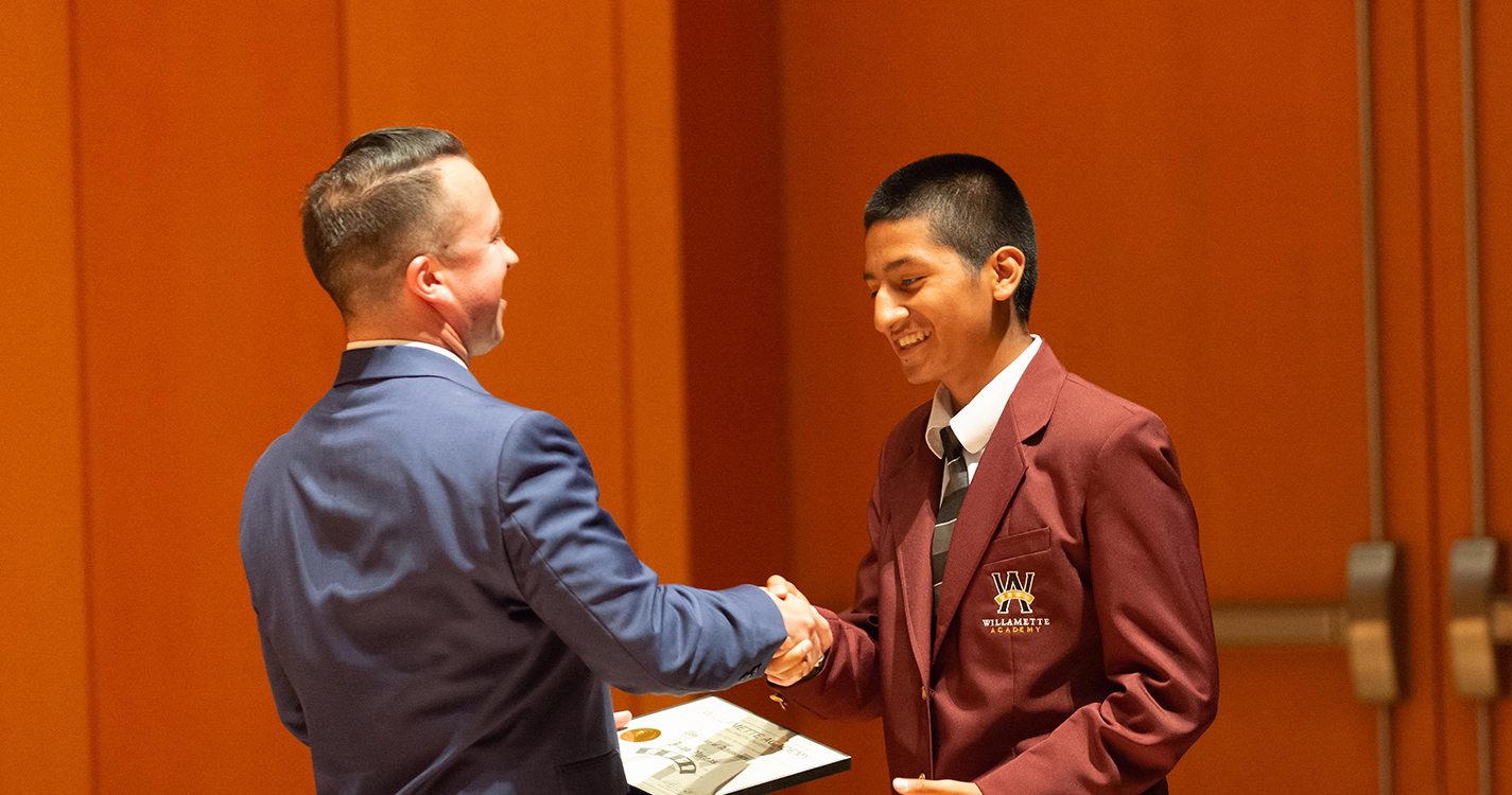 Graduate receives a certificate and handshake from Executive Director Emilio Solano 
