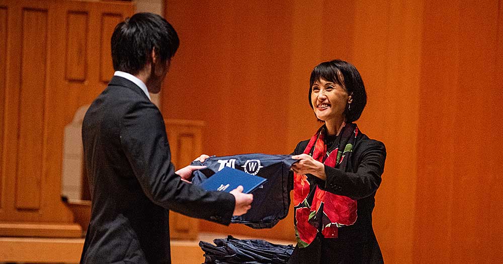 Student receives gift at the ASP closing ceremony from Tomoko Harpster, Associate Director of Academic Administration at TIUA.