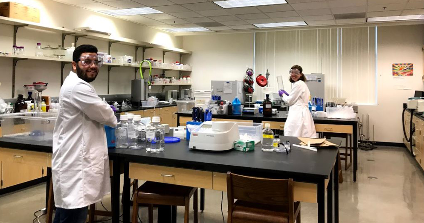 Lab assistants prepare chemicals at distanced tables
