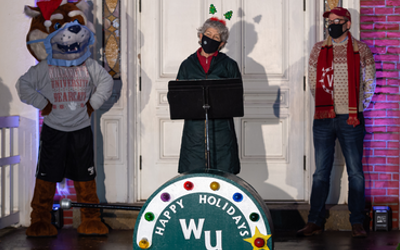 karen wood, president thorsett, and blitz the bearcat pose in front of Waller Hall