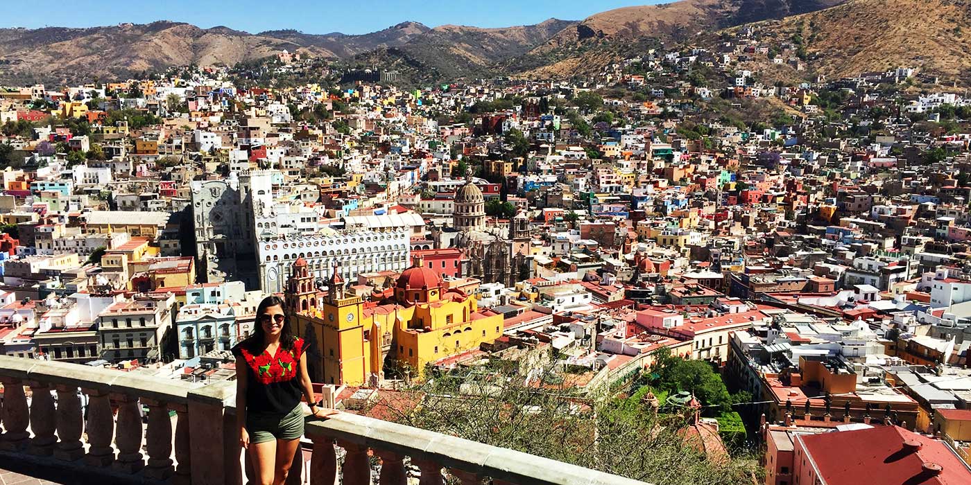 Elizabeth Guzman Ljubetic ’14 stands on a ridge overlooking a city in the mountains of Spain