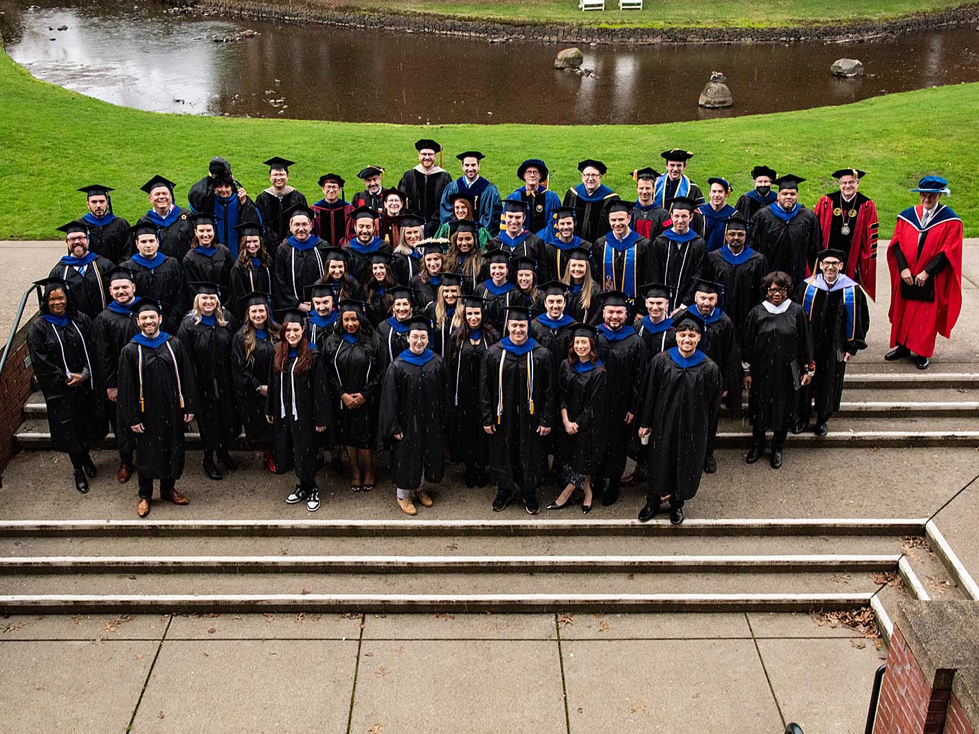 Graduates in front of millstream