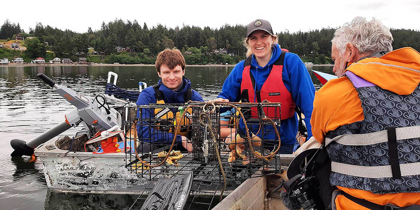 Team members Ella Ashford and Logan Flanagan pull a recovered crab pot from the sea. Photo credit: Monica Montgomery