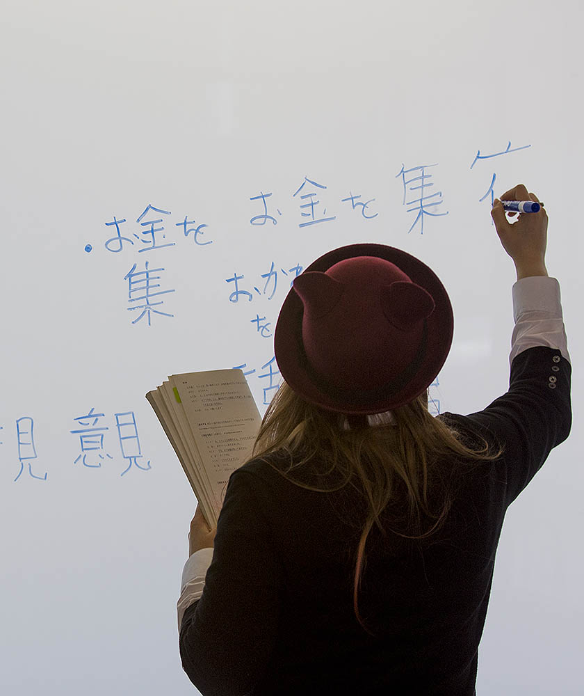 Student writing Japanese on a white board
