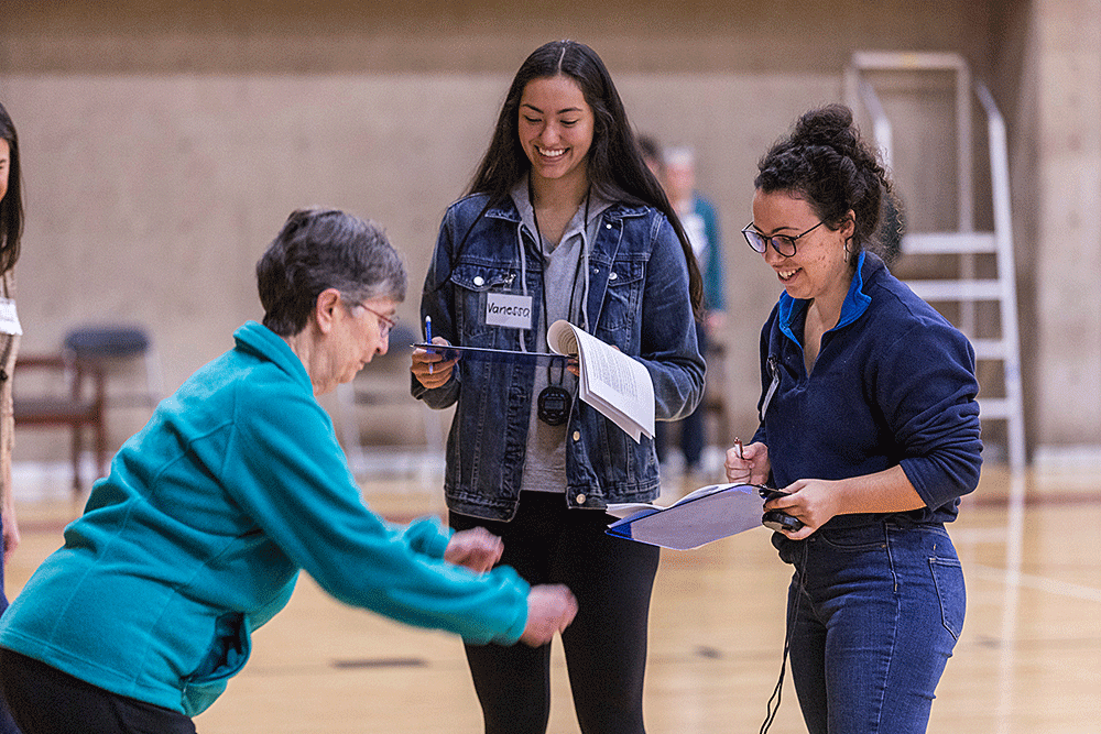 two students conduct functional tests of strength, balance, and gait function with an older adult community member in our aging, health, and functional assessment course
